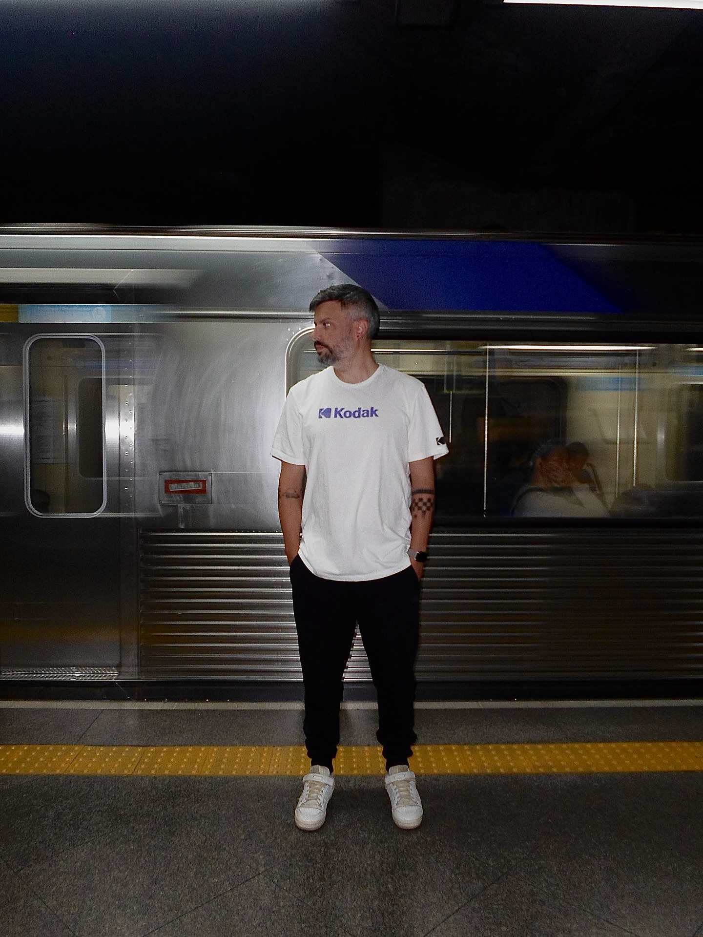 Guilherme standing on a platform beside a passing train